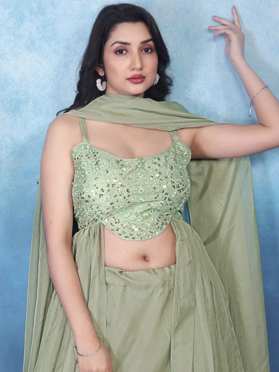 Woman wearing a green traditional outfit with a plain background