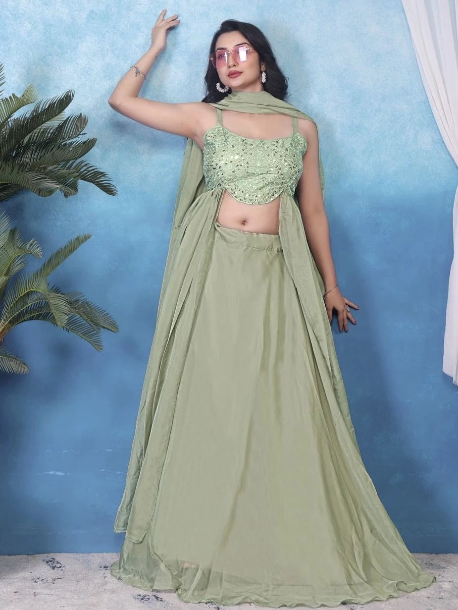 Woman wearing a green saree with a blue background