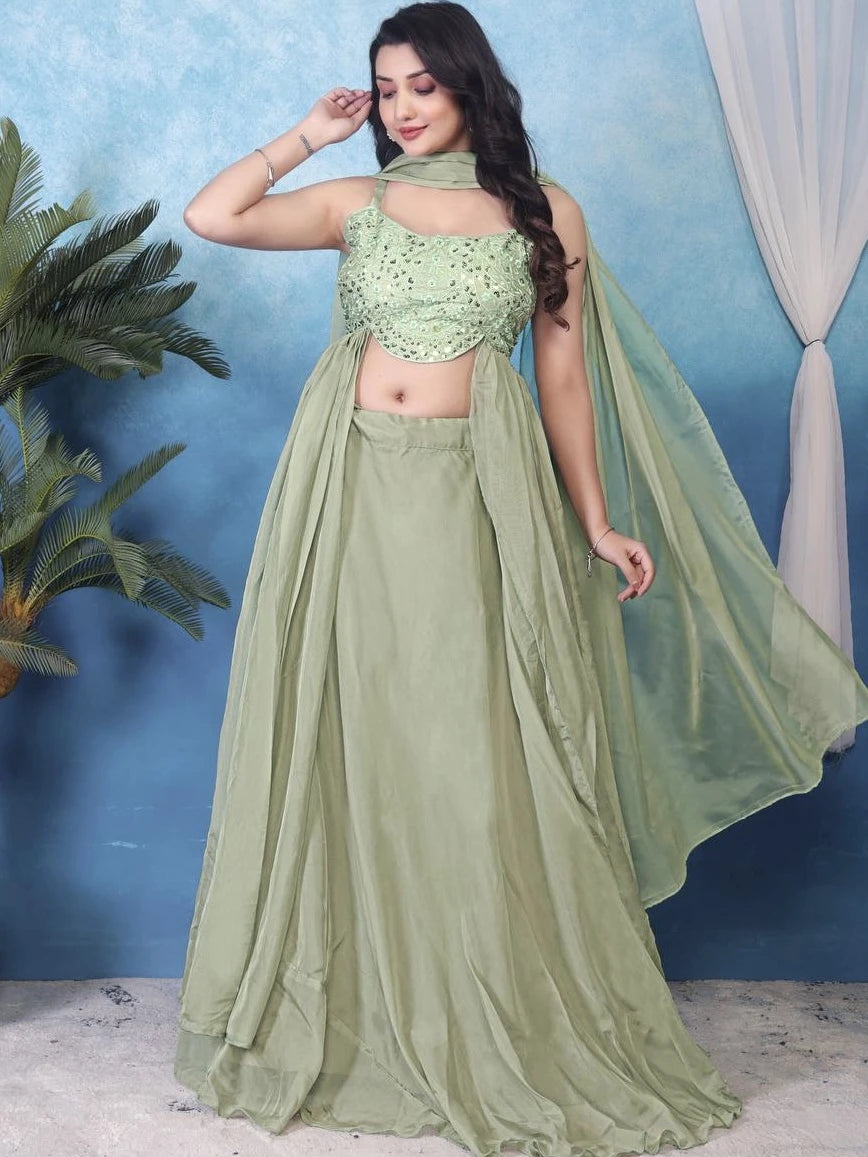 Woman wearing a green traditional outfit with a blue background