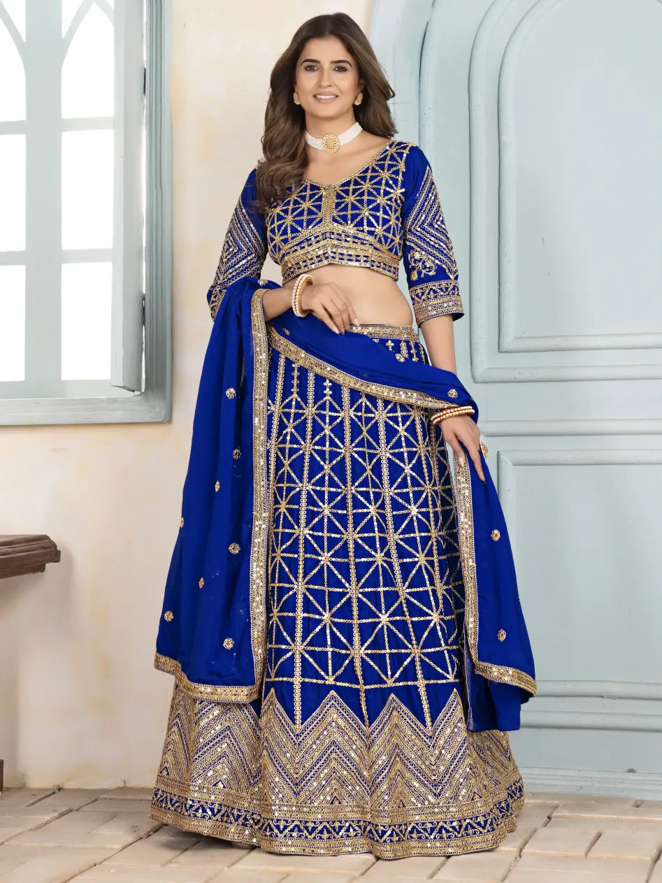 Woman wearing a blue embroidered traditional outfit indoors.