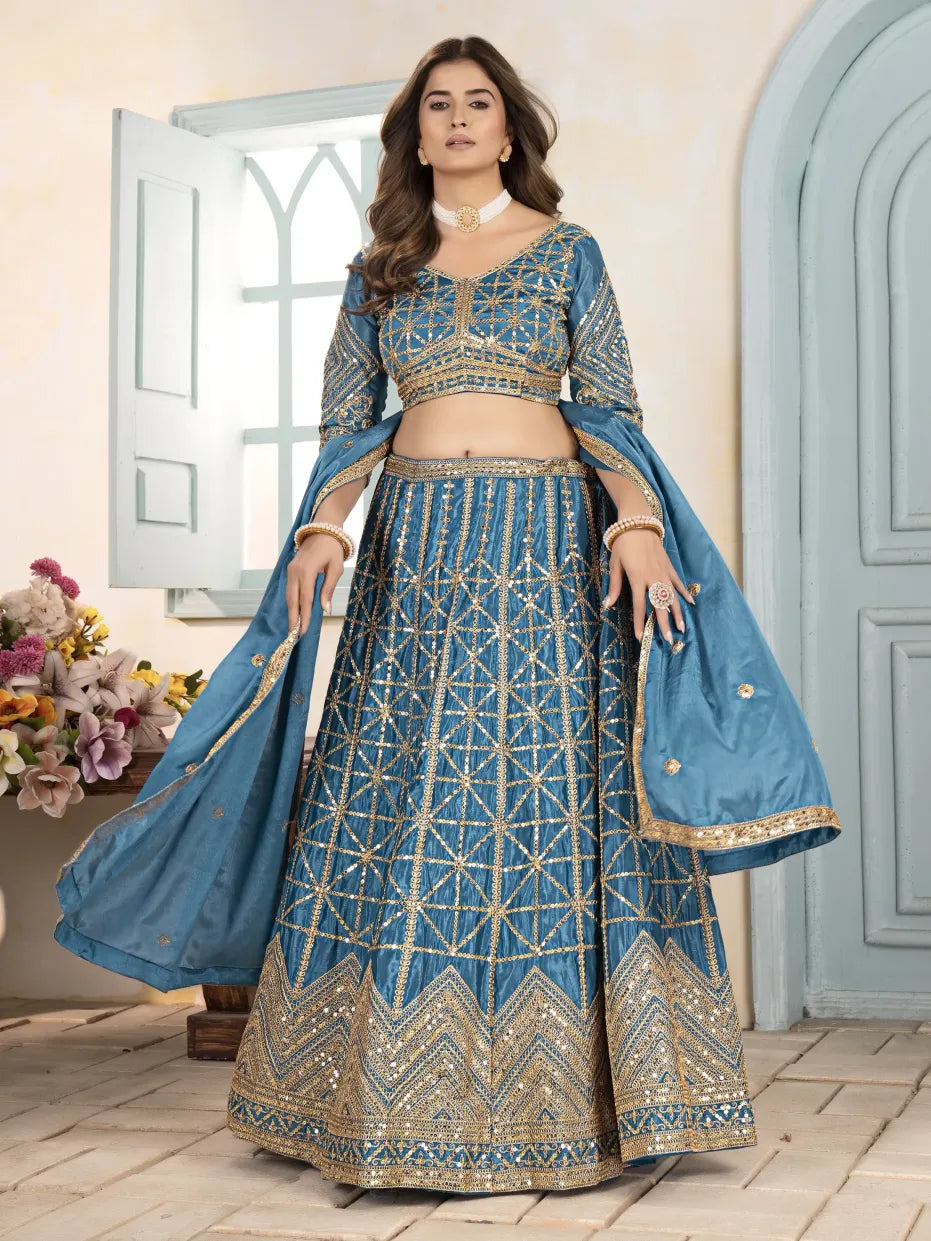 Woman wearing a blue embroidered traditional outfit in a well-lit room.