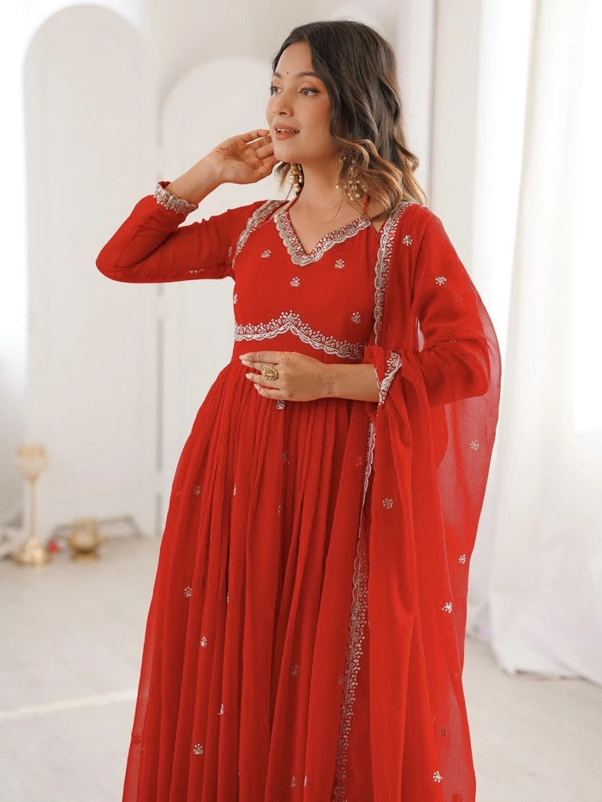 Woman wearing a red traditional outfit with white embroidery in a minimalistic setting