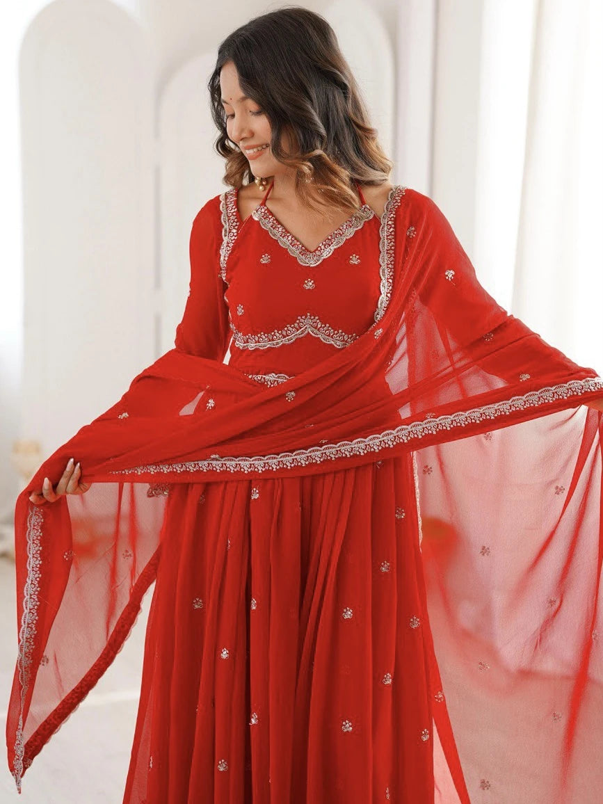 Woman wearing a red traditional outfit with white embroidery in a bright setting