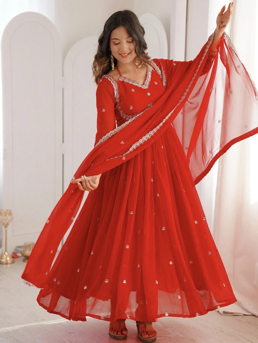 Woman wearing a red traditional outfit with a matching dupatta in a bright setting