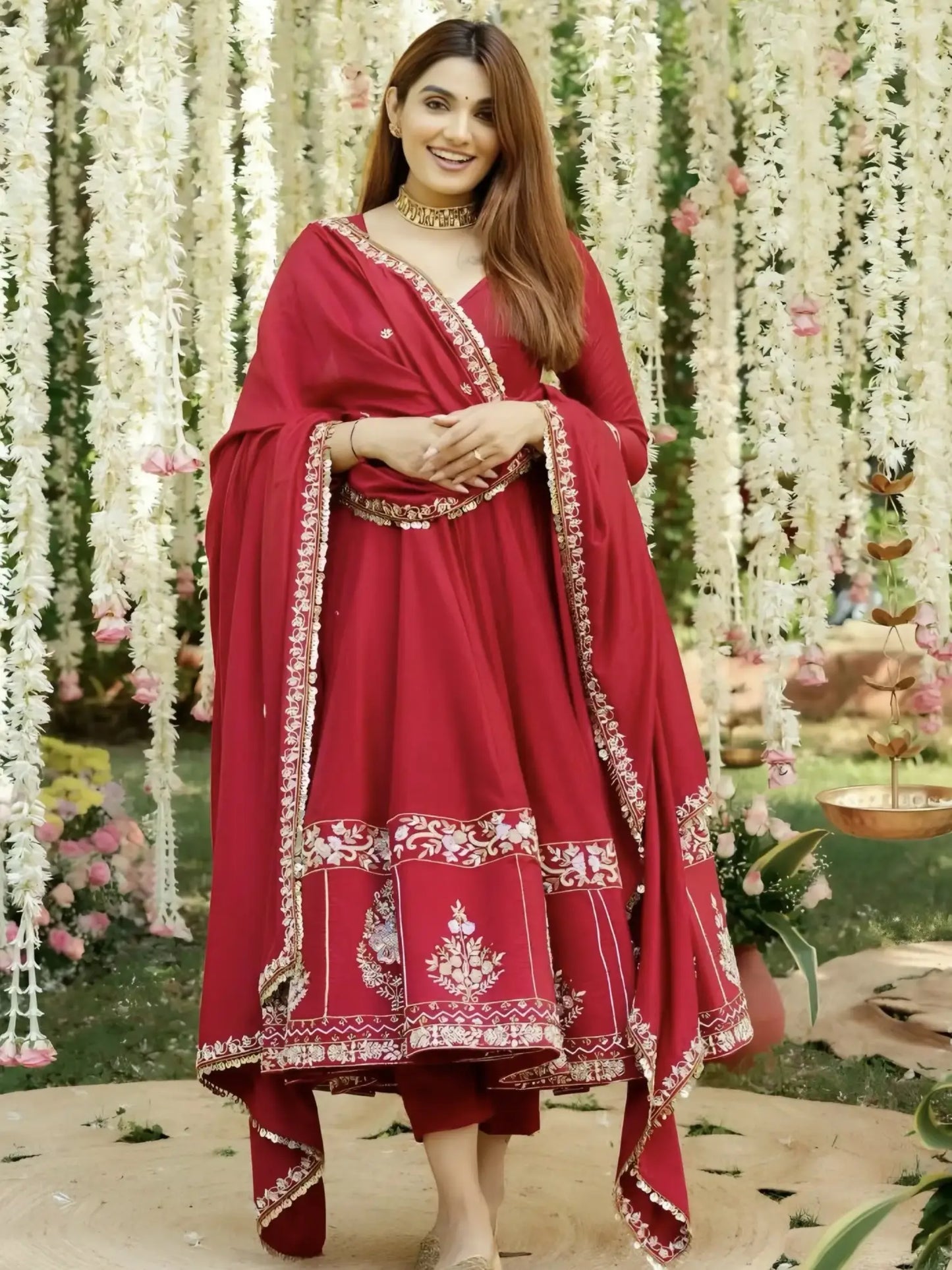 Woman in a red traditional outfit with floral decorations in the background