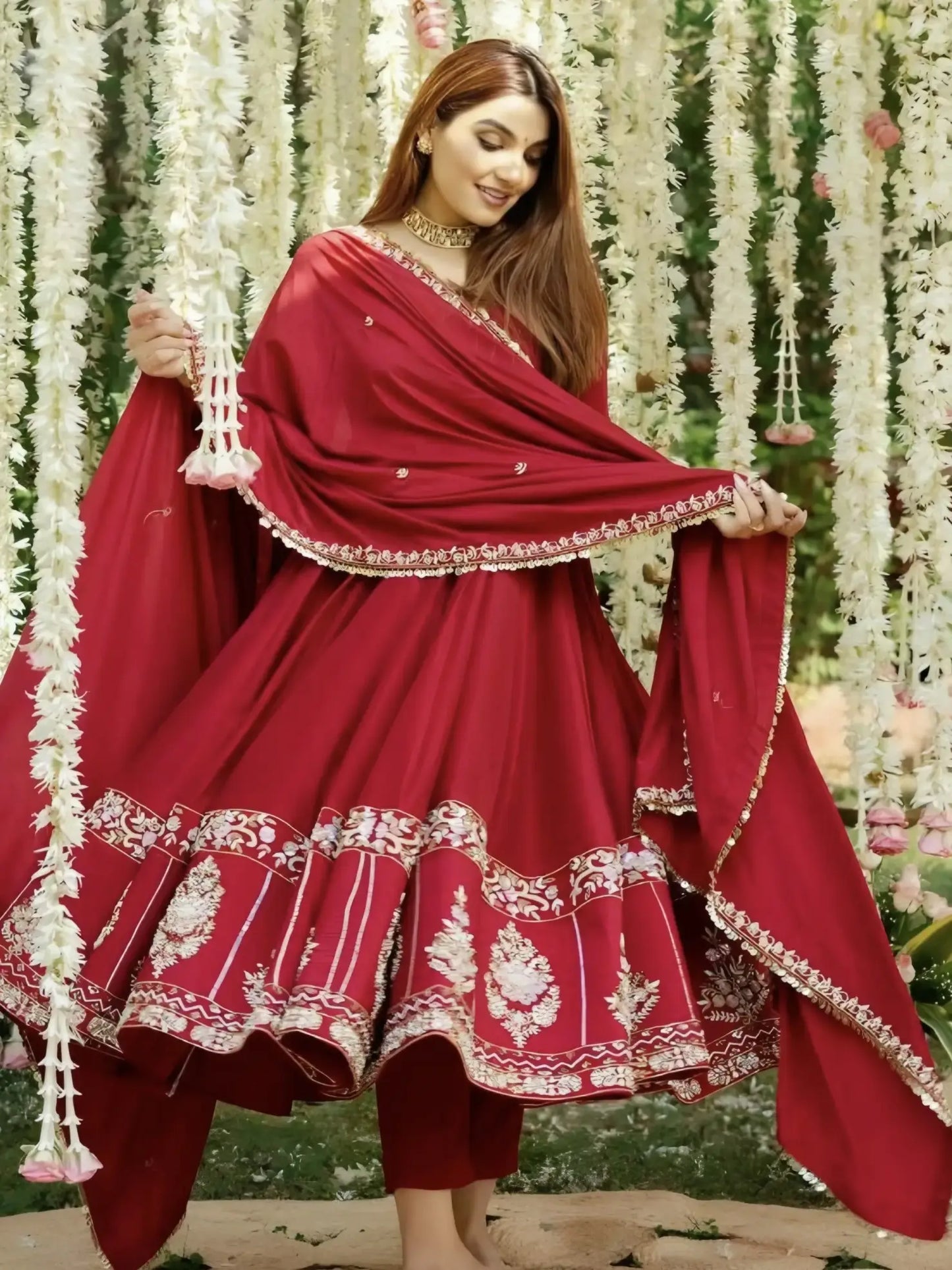 Woman in a red traditional outfit with white embroidery against a floral background