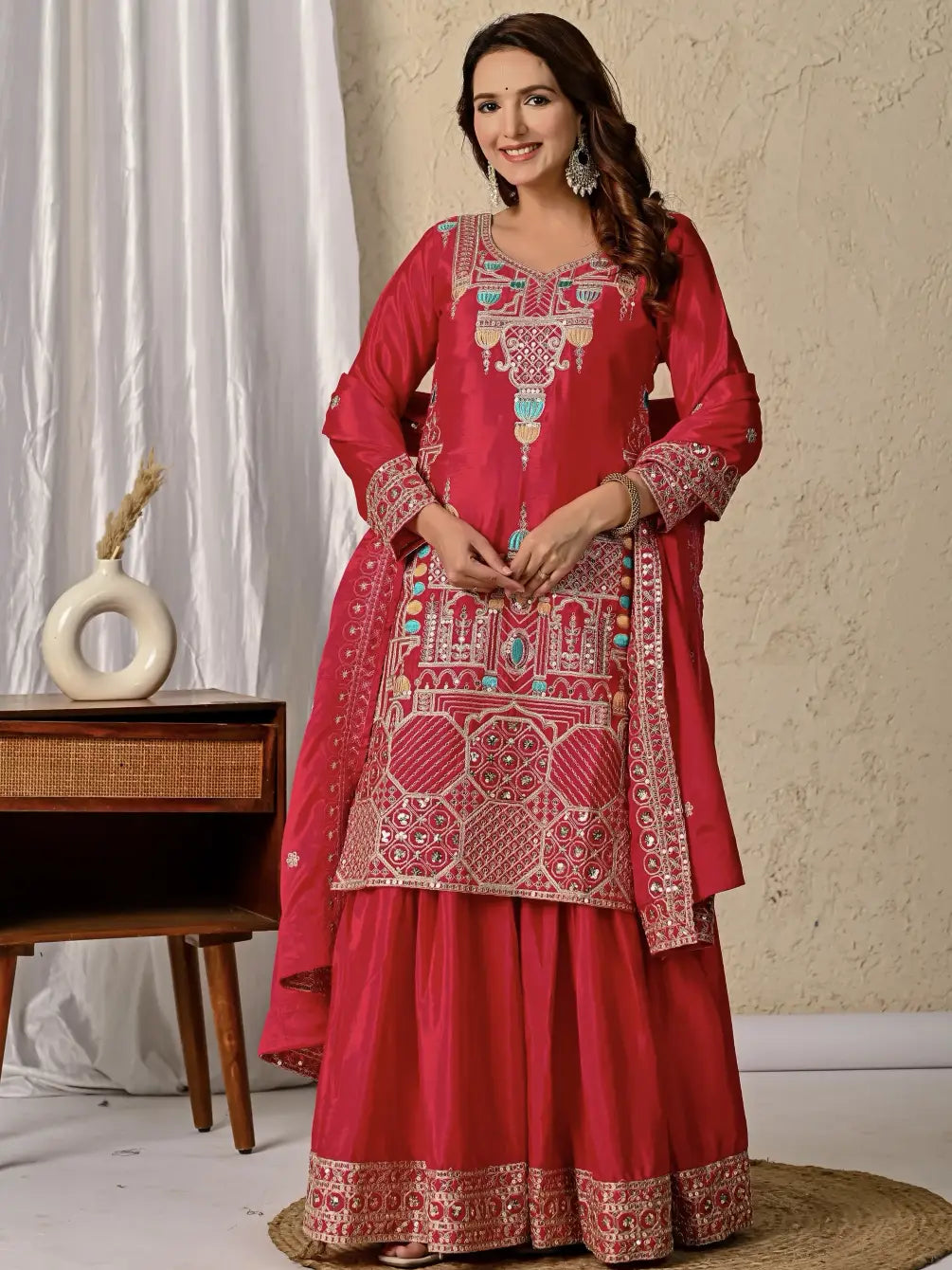 Woman wearing a red embroidered traditional outfit with a neutral background