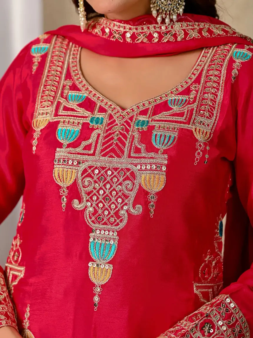 Red embroidered garment with intricate patterns and embellishments.