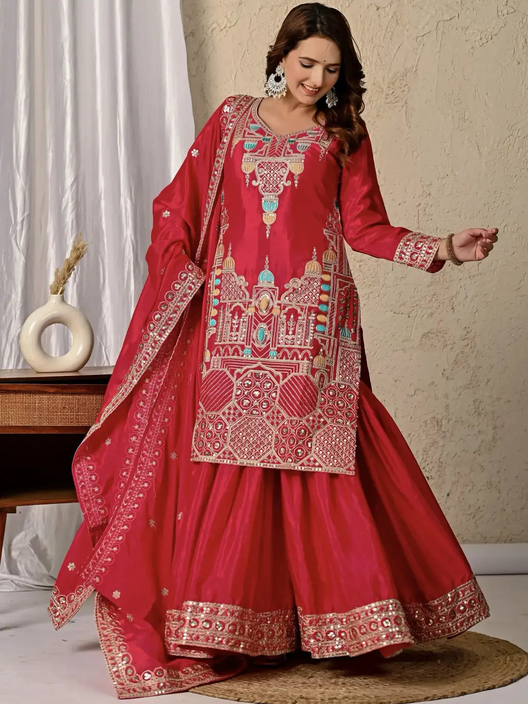 Woman wearing a red embroidered traditional outfit with a neutral background