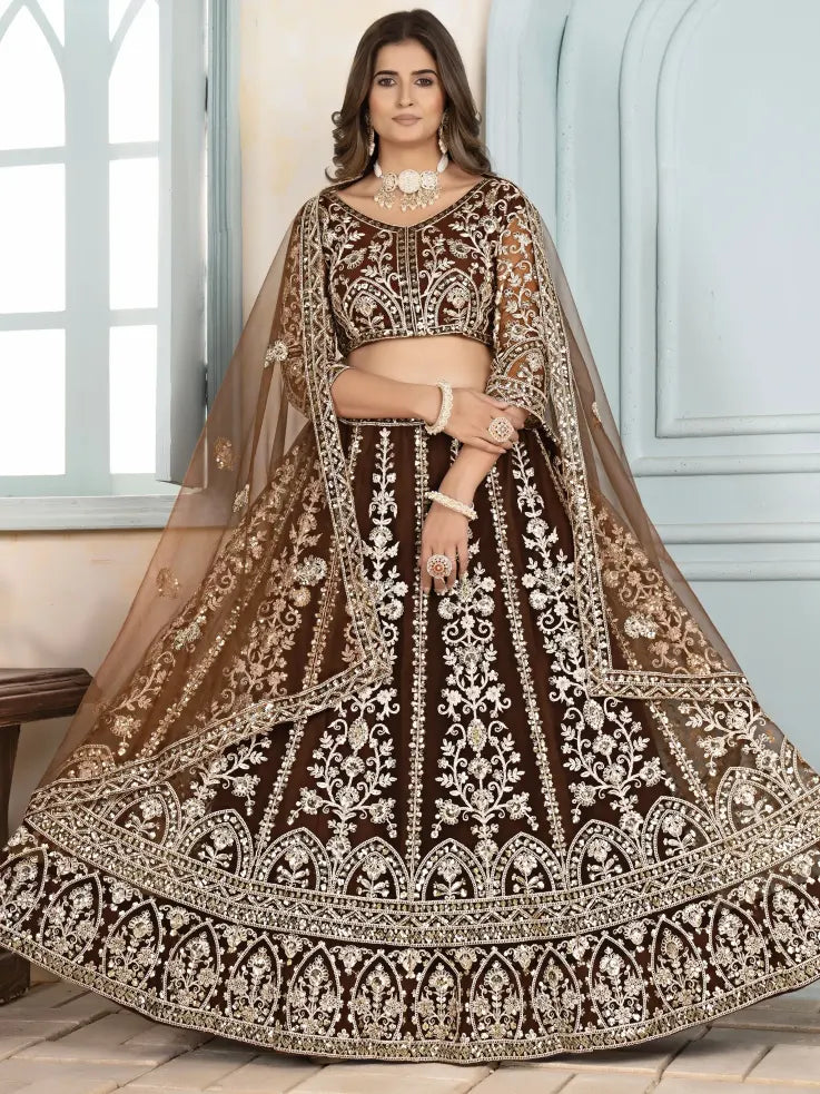 Woman wearing a brown and gold embroidered traditional outfit indoors.