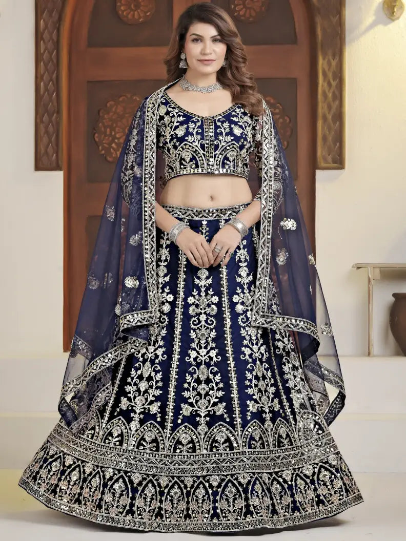Woman wearing a traditional navy blue and white embroidered lehenga with a matching dupatta.