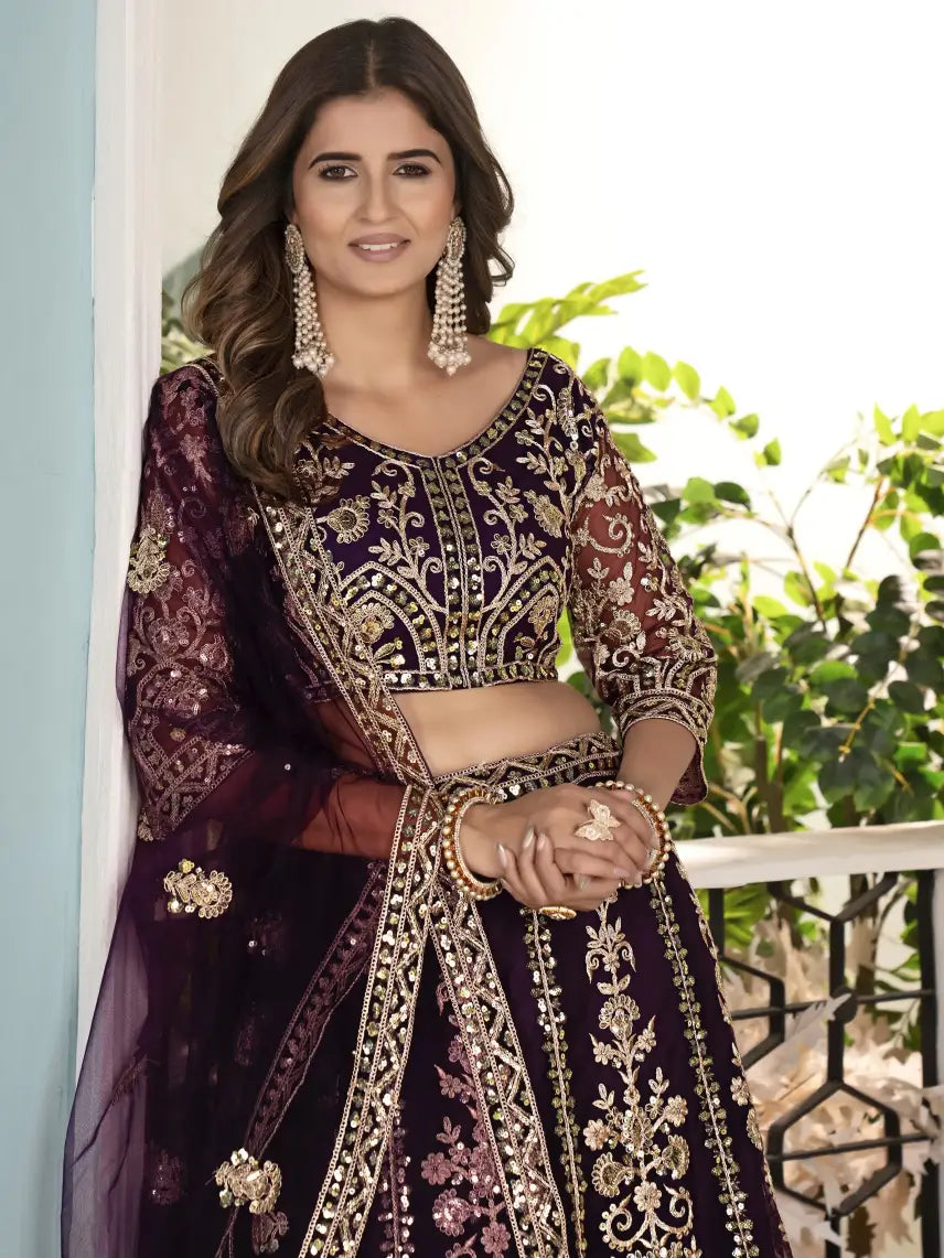 Woman wearing a traditional embroidered outfit with jewelry, standing outdoors.