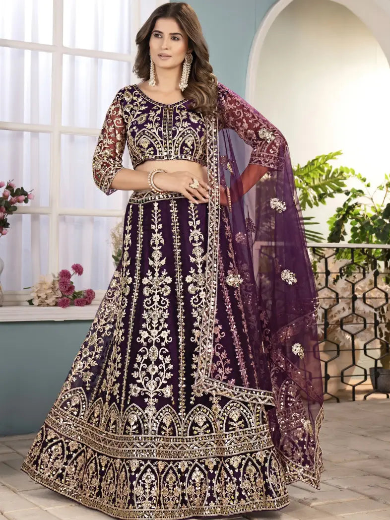 Woman wearing a traditional purple and gold embroidered outfit indoors.