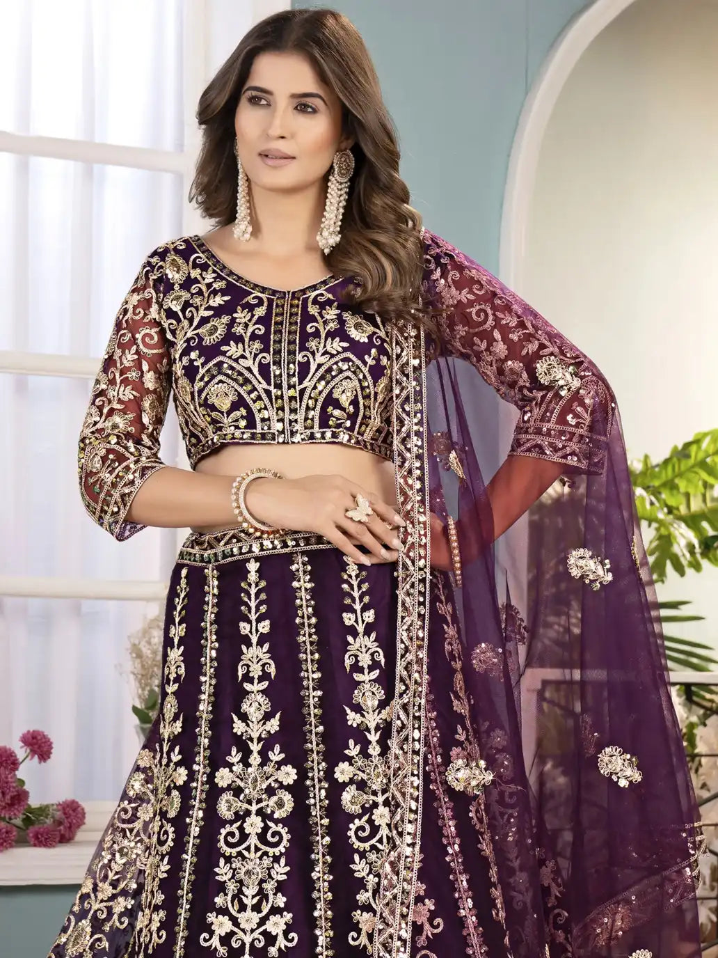 Woman wearing a traditional embroidered outfit with a purple and gold color scheme.