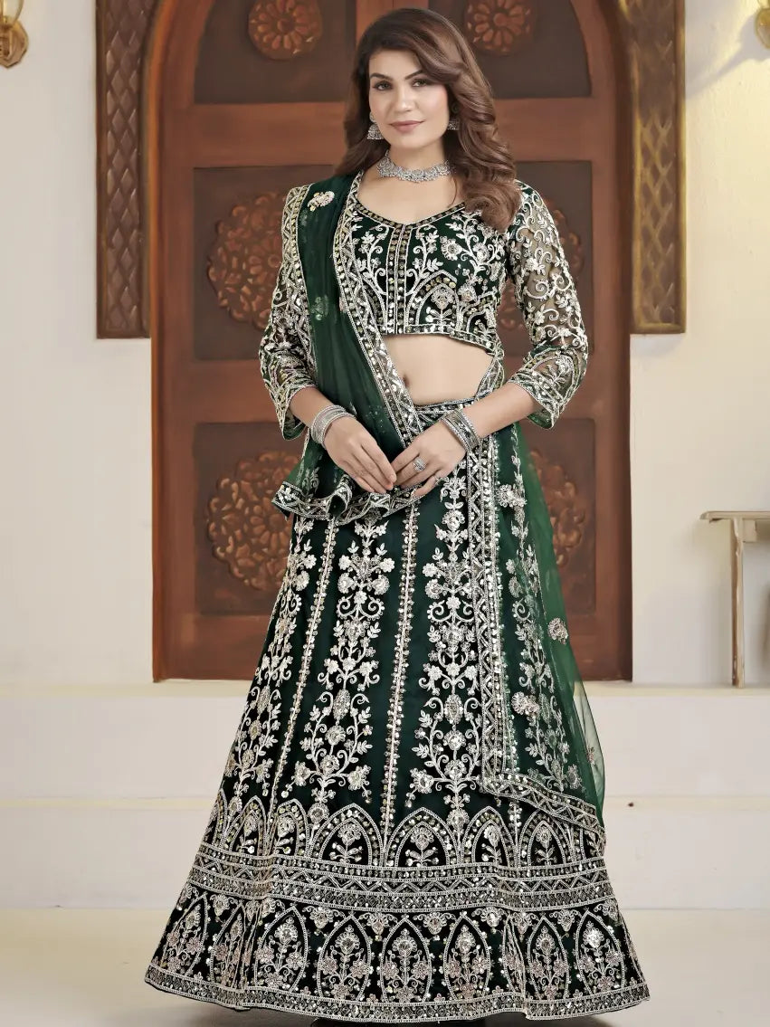 Woman wearing a green and black embroidered traditional outfit indoors.
