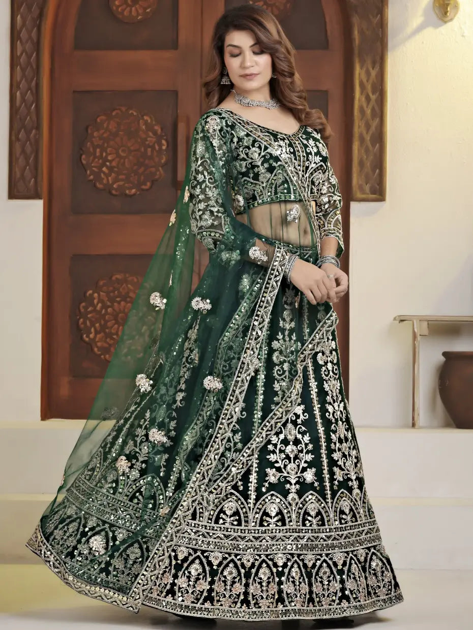Woman wearing a green and black embroidered traditional outfit indoors.