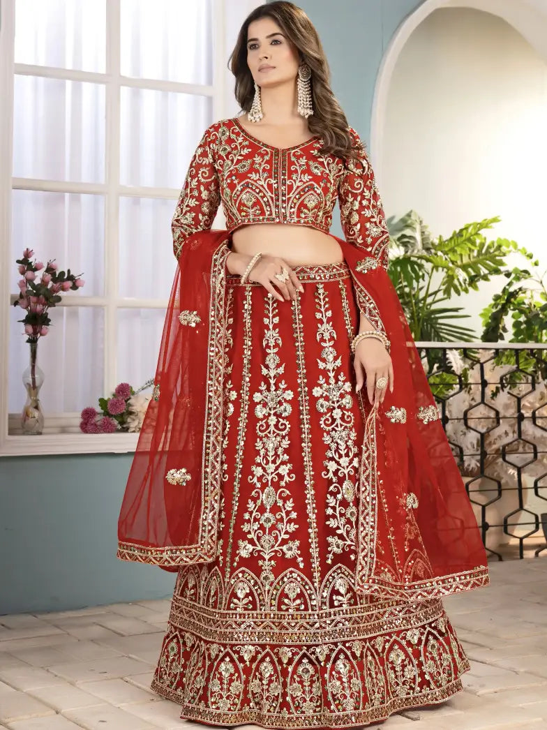 Woman wearing a red and gold embroidered traditional outfit with a white background
