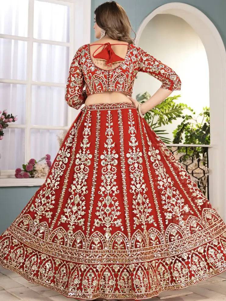 Red and white embroidered traditional outfit with a person wearing it indoors.