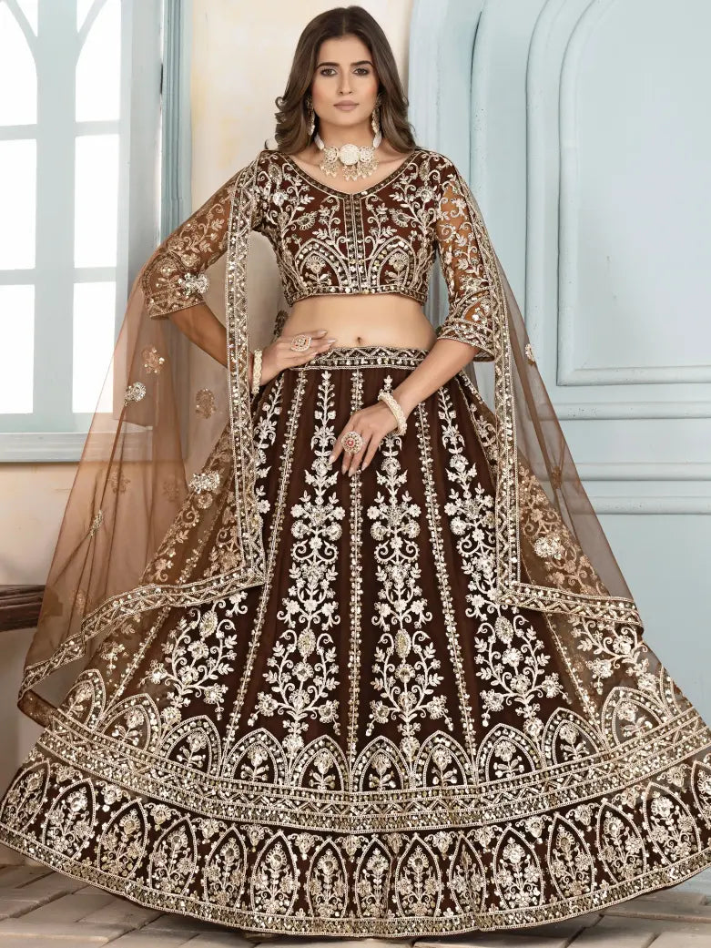 Woman wearing a traditional brown and gold embroidered lehenga with a white background