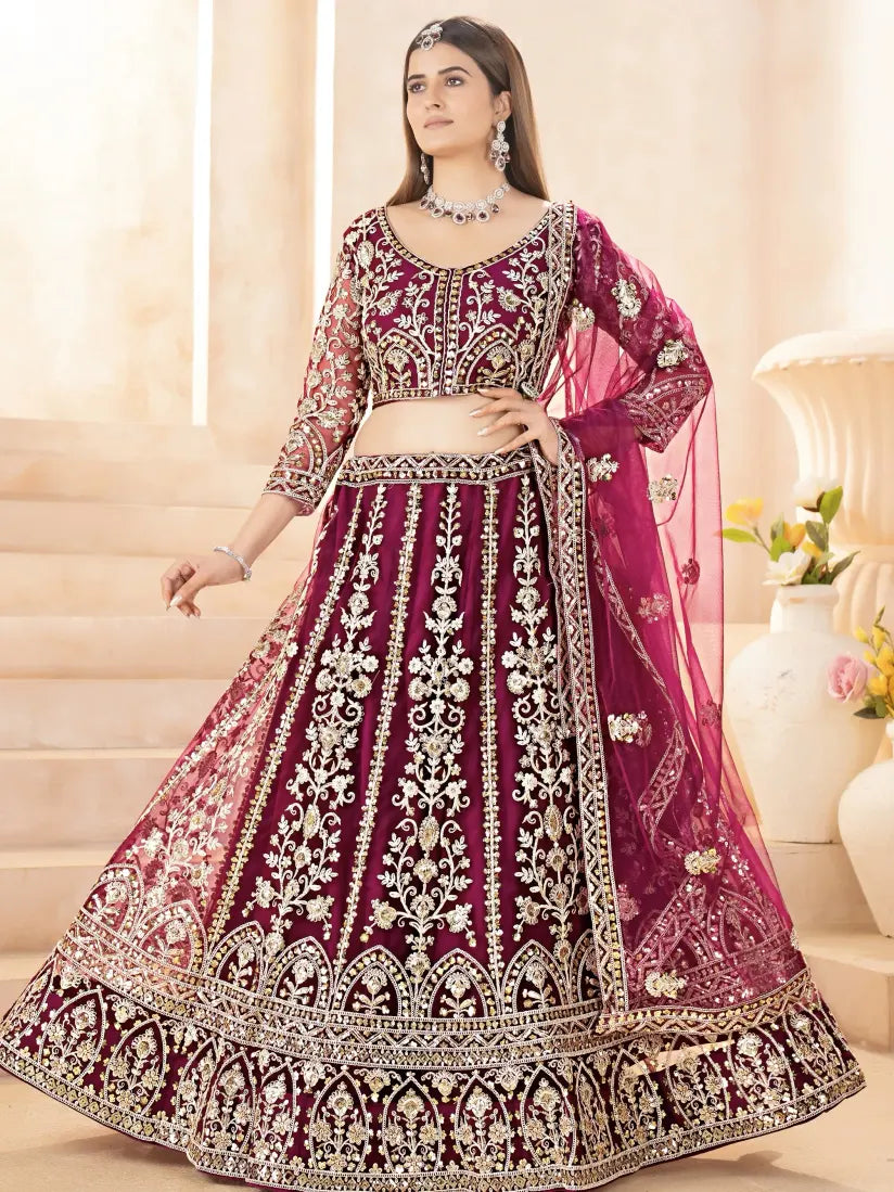 Woman wearing a traditional embroidered purple and pink lehenga with a white background
