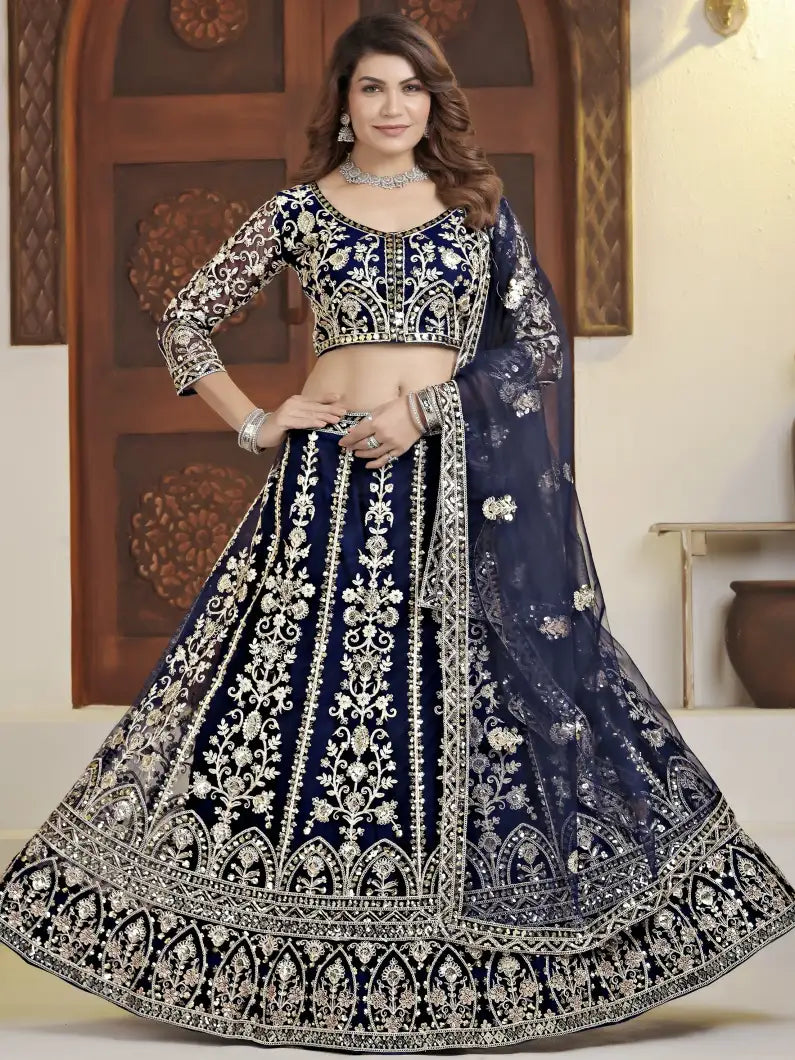 Woman wearing a traditional navy blue and white embroidered lehenga with a matching blouse.