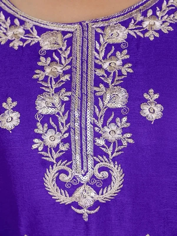 Close-up of a purple fabric with intricate silver floral embroidery
