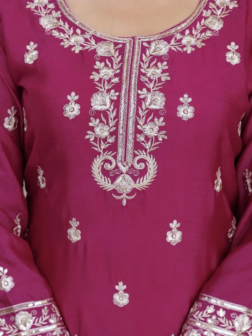 Close-up of a maroon fabric with intricate white embroidery