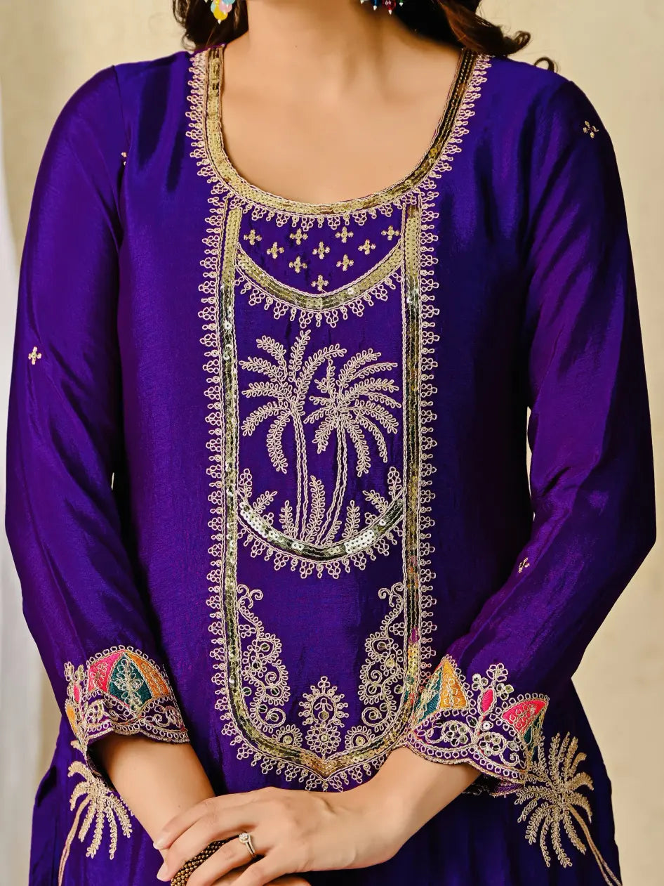 Purple embroidered dress with intricate patterns on a beige background