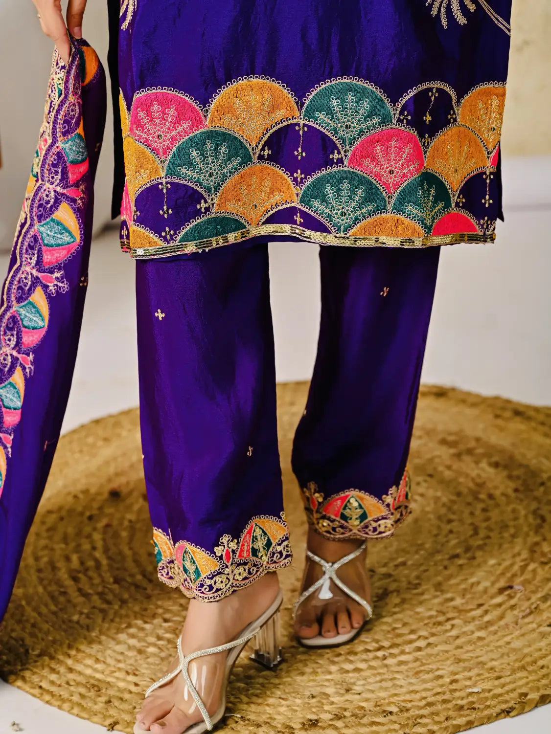Purple traditional outfit with colorful embroidery on a textured surface