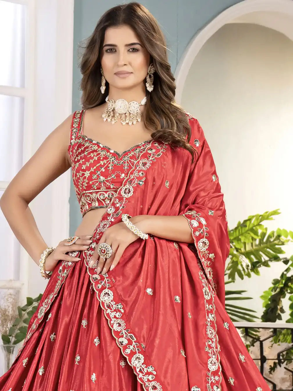 Woman wearing a red embroidered saree with a white background