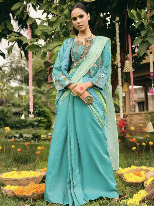 Woman in a teal saree with floral decorations in an outdoor setting