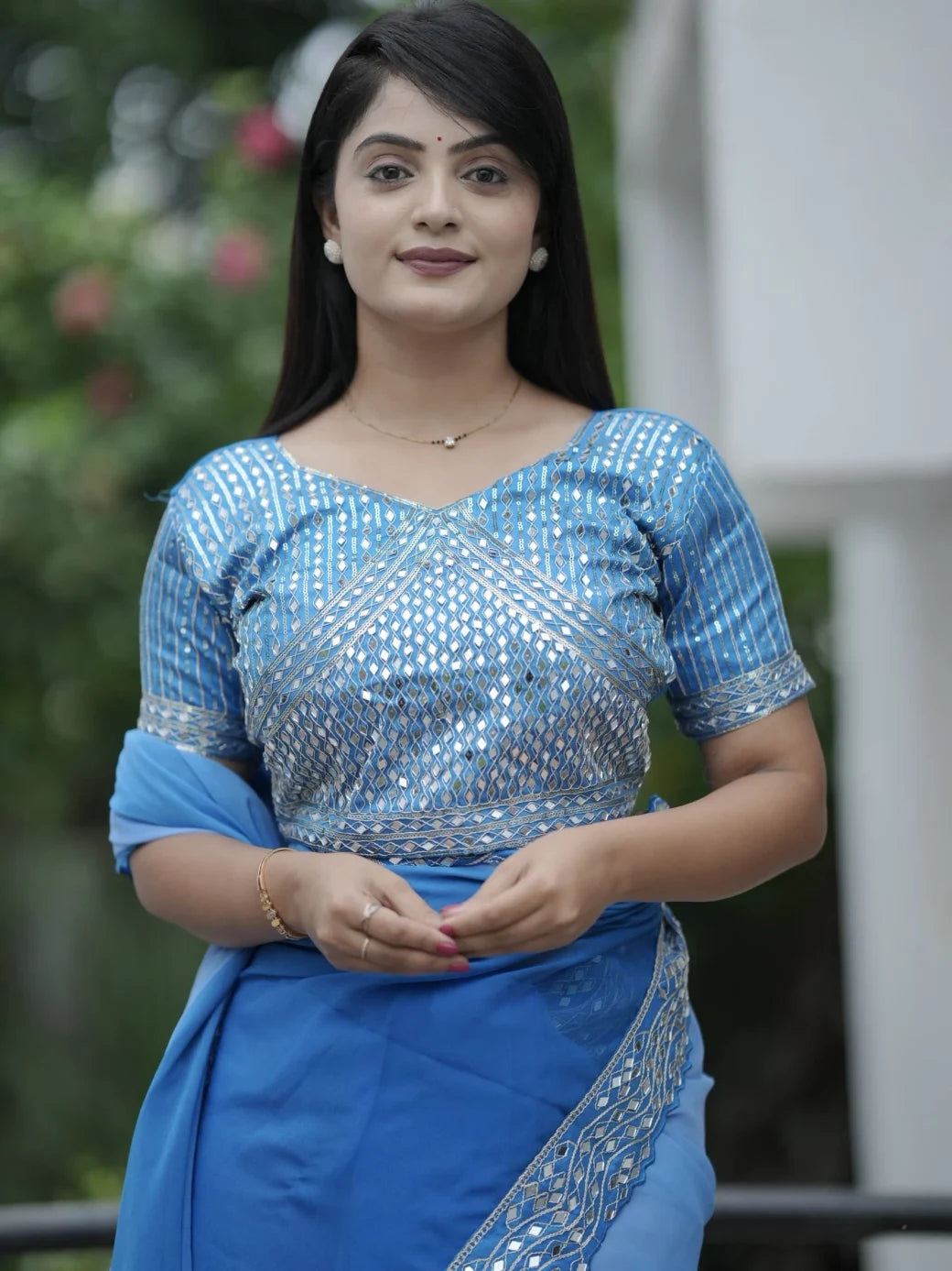 Woman wearing a blue saree with silver border outdoors