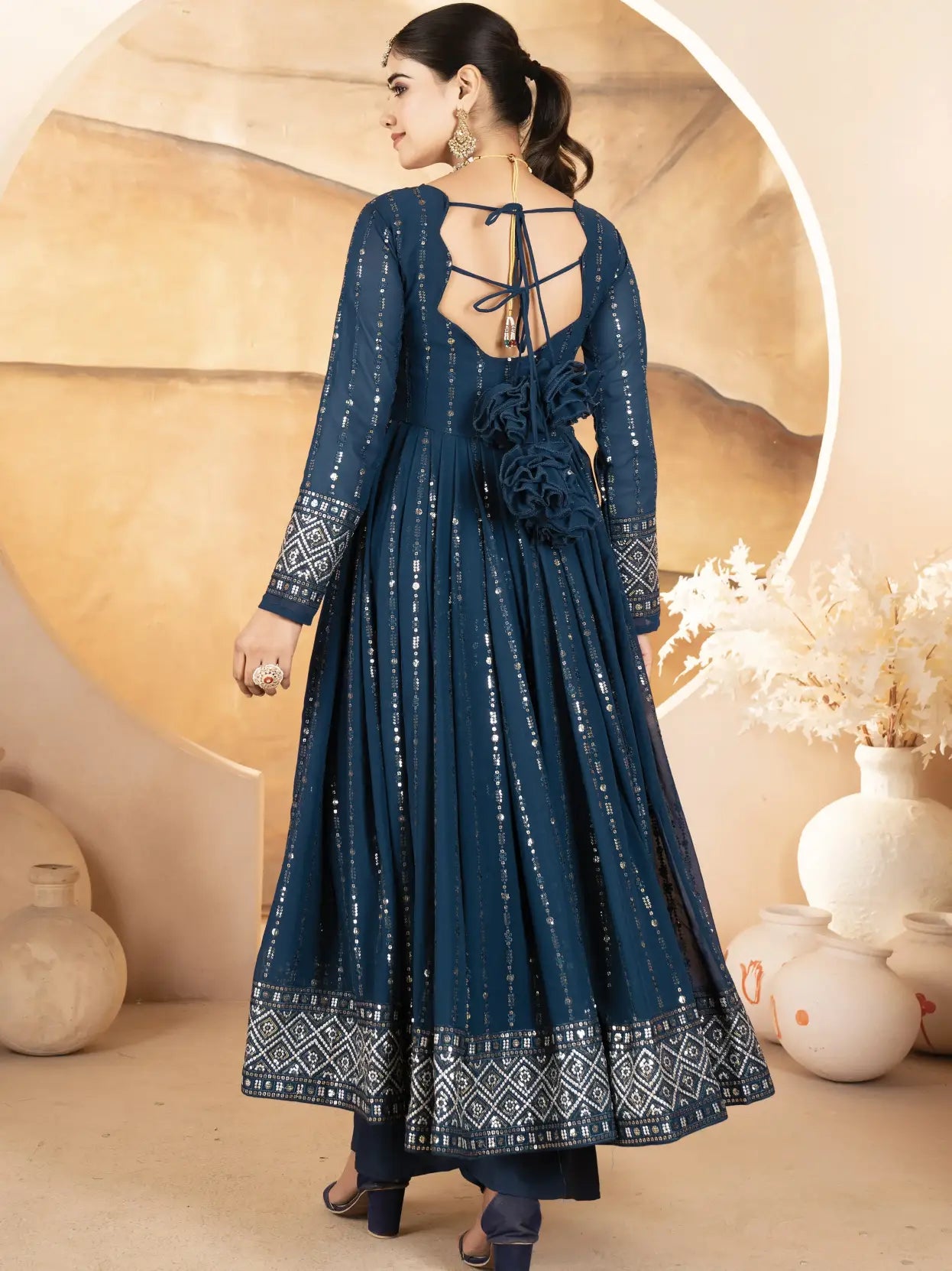 Woman wearing a blue patterned dress with a neutral background