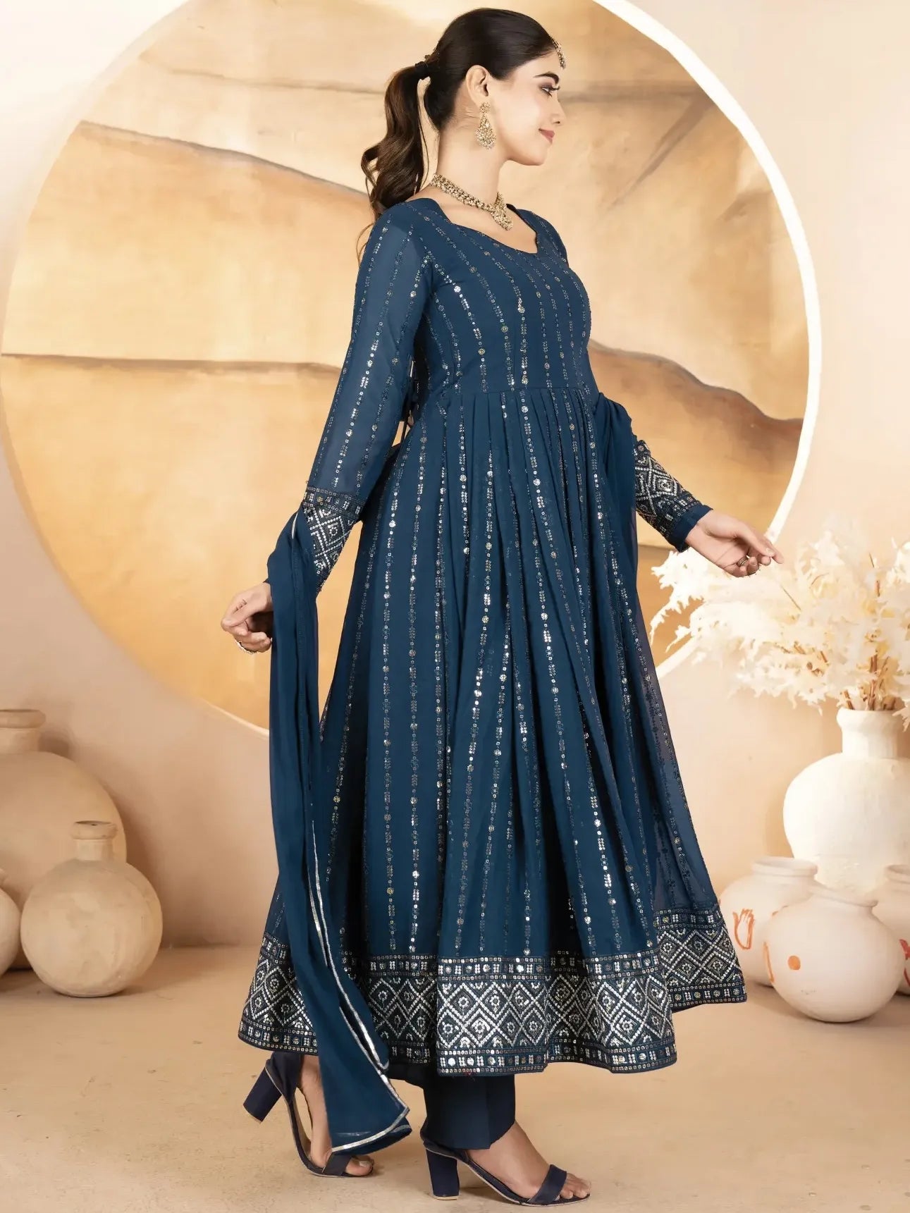 Woman wearing a blue patterned dress with a neutral background