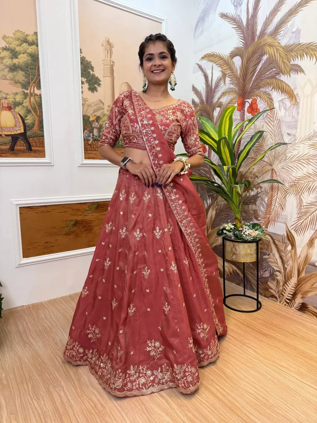 Woman in a red traditional outfit standing in a room with decorative elements.