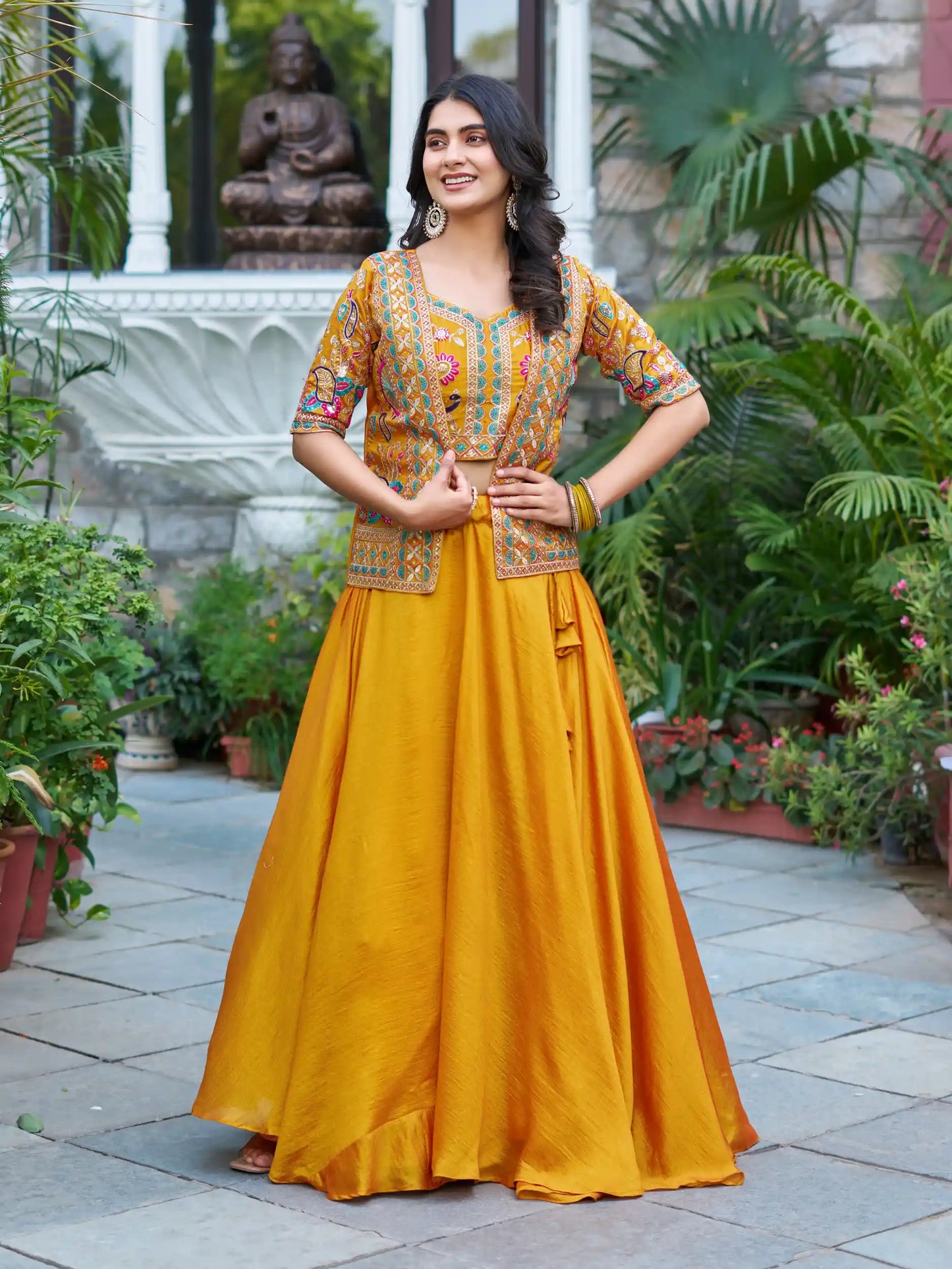 Woman in a yellow traditional outfit standing in a garden setting