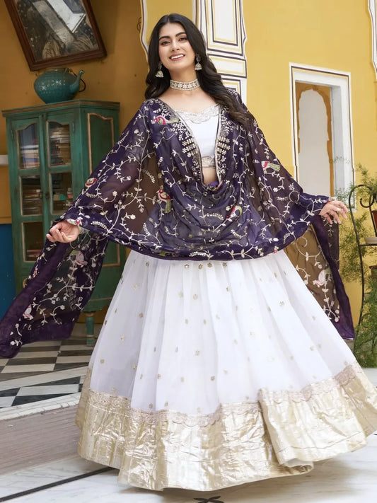 Woman in a traditional outfit with a floral dupatta in an indoor setting