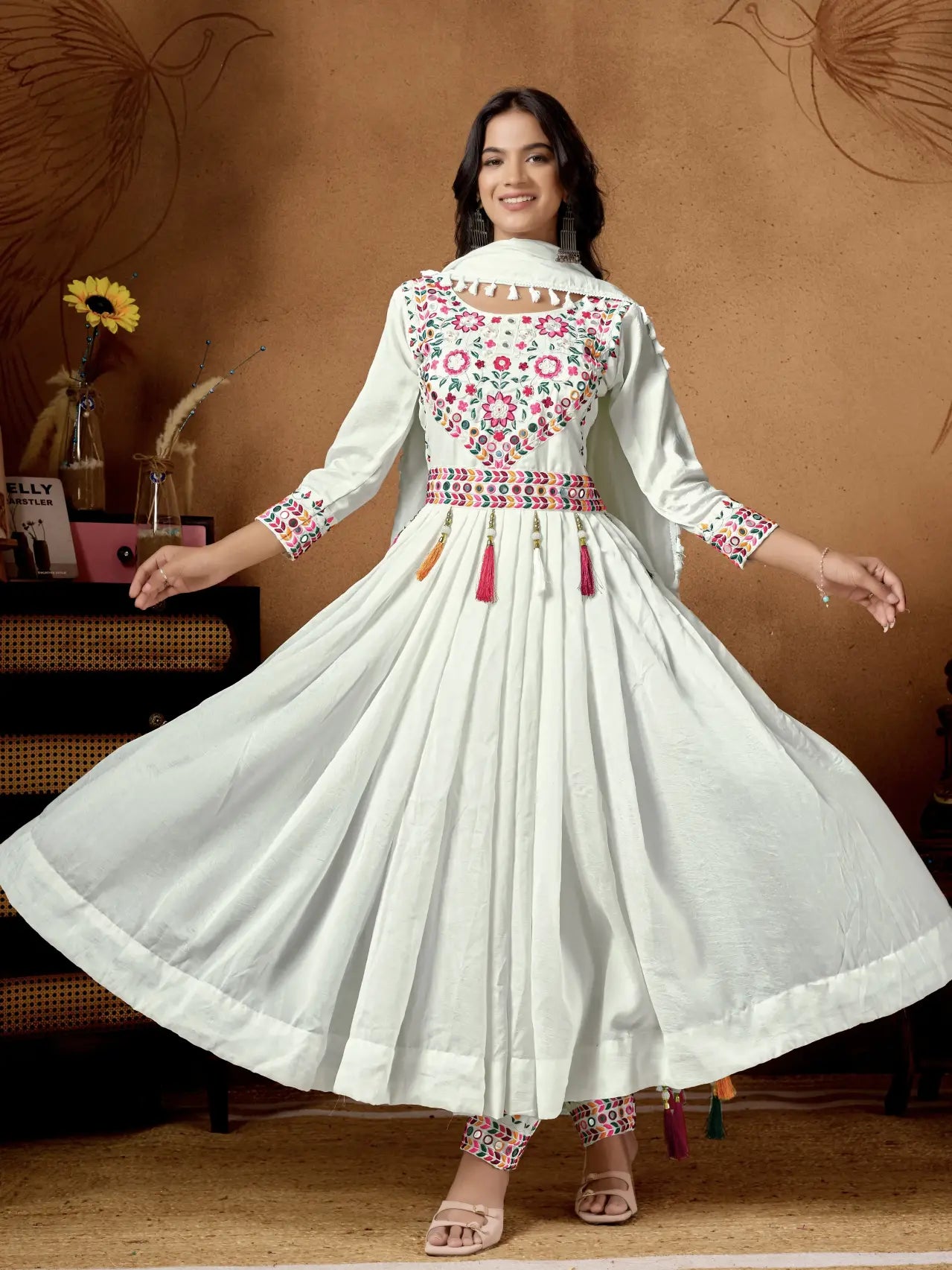 Woman wearing a white embroidered dress with a brown background