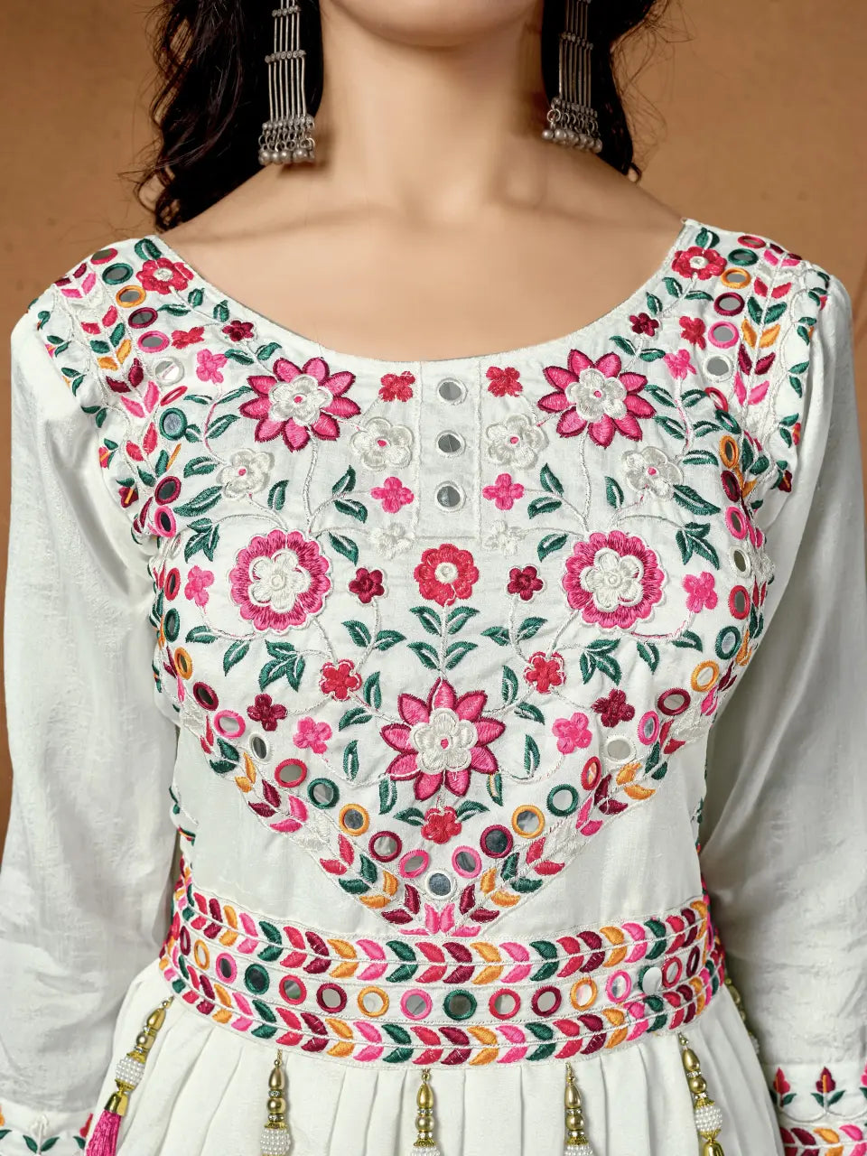 White outfit with colorful floral embroidery on a plain background